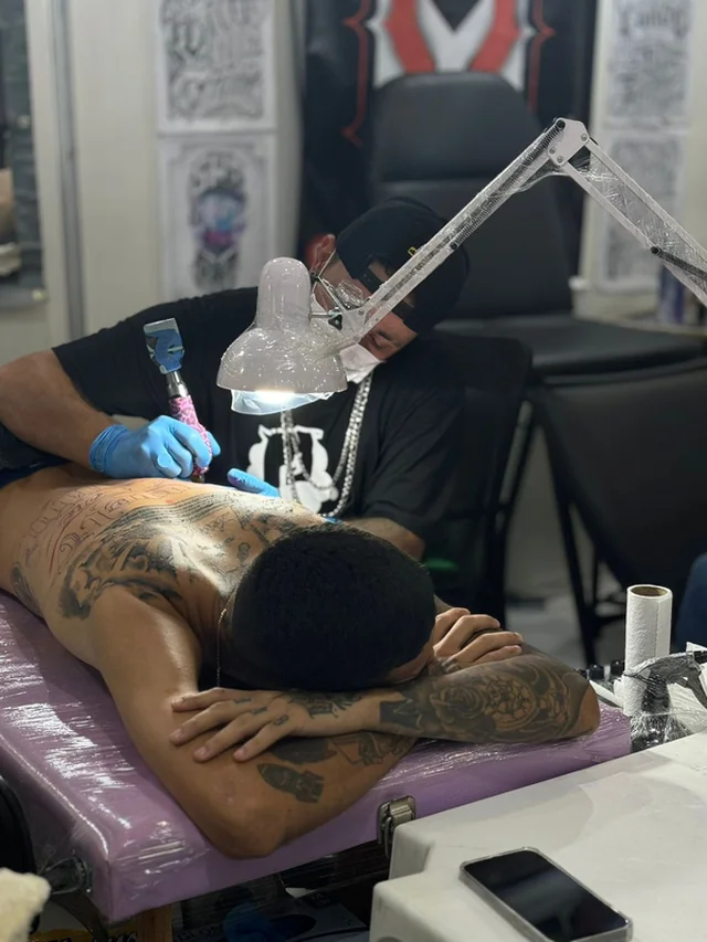 Tatuador trabalhando em uma tatuagem